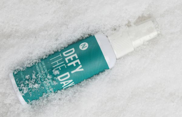 Lifestyle shot of the Defy the Day Leave-in Conditioner Spray in snow.